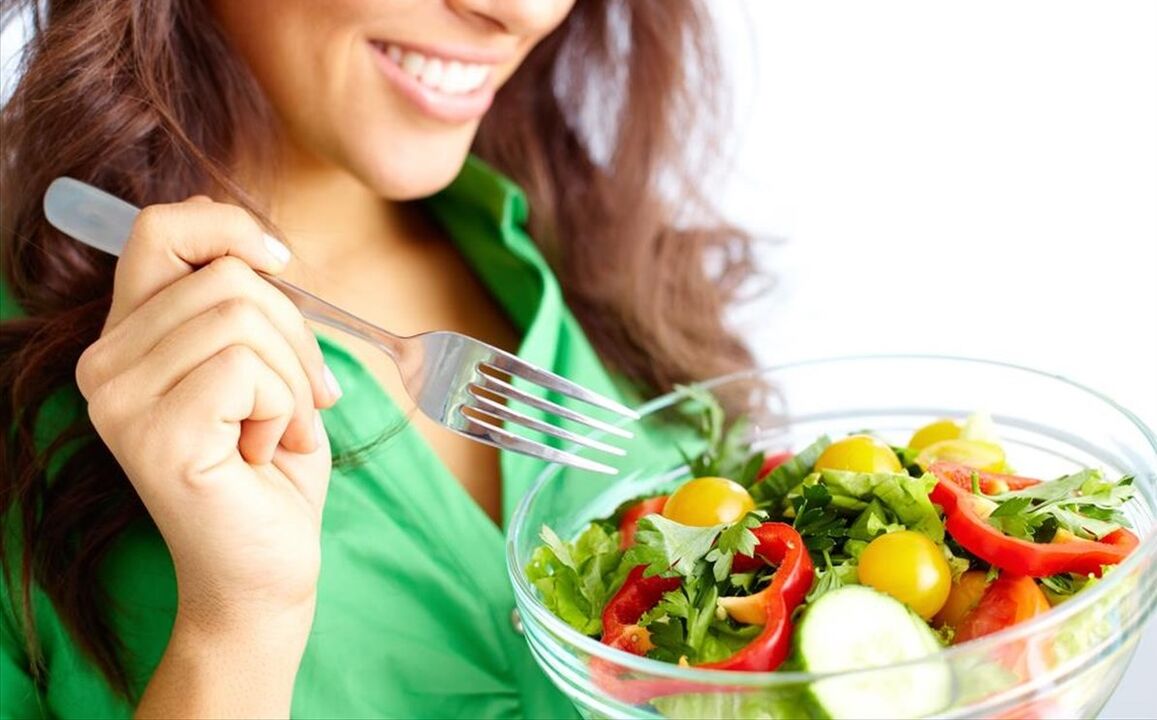 The girl eats a vegetable salad on a 6-sheet diet