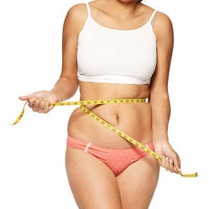 An overweight girl measures her waist